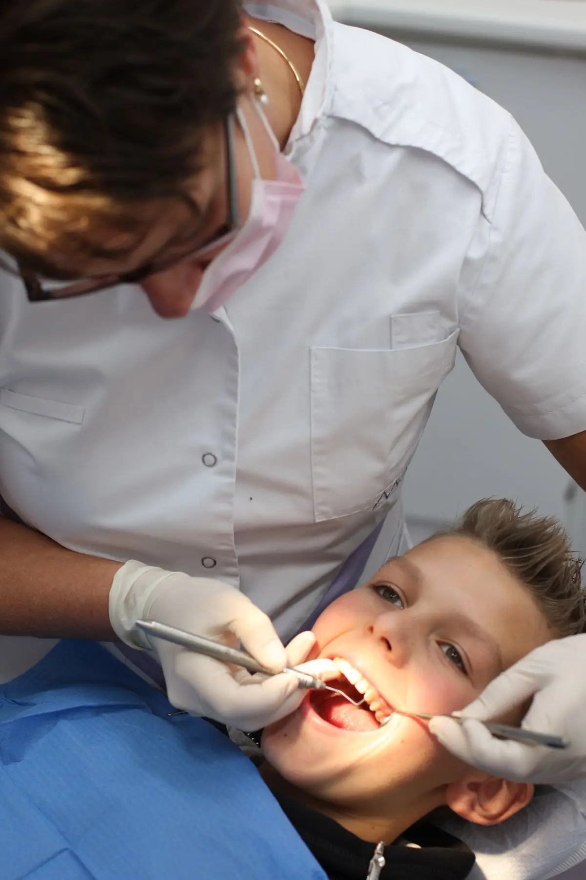 A children's dentist examining a boy's teeth